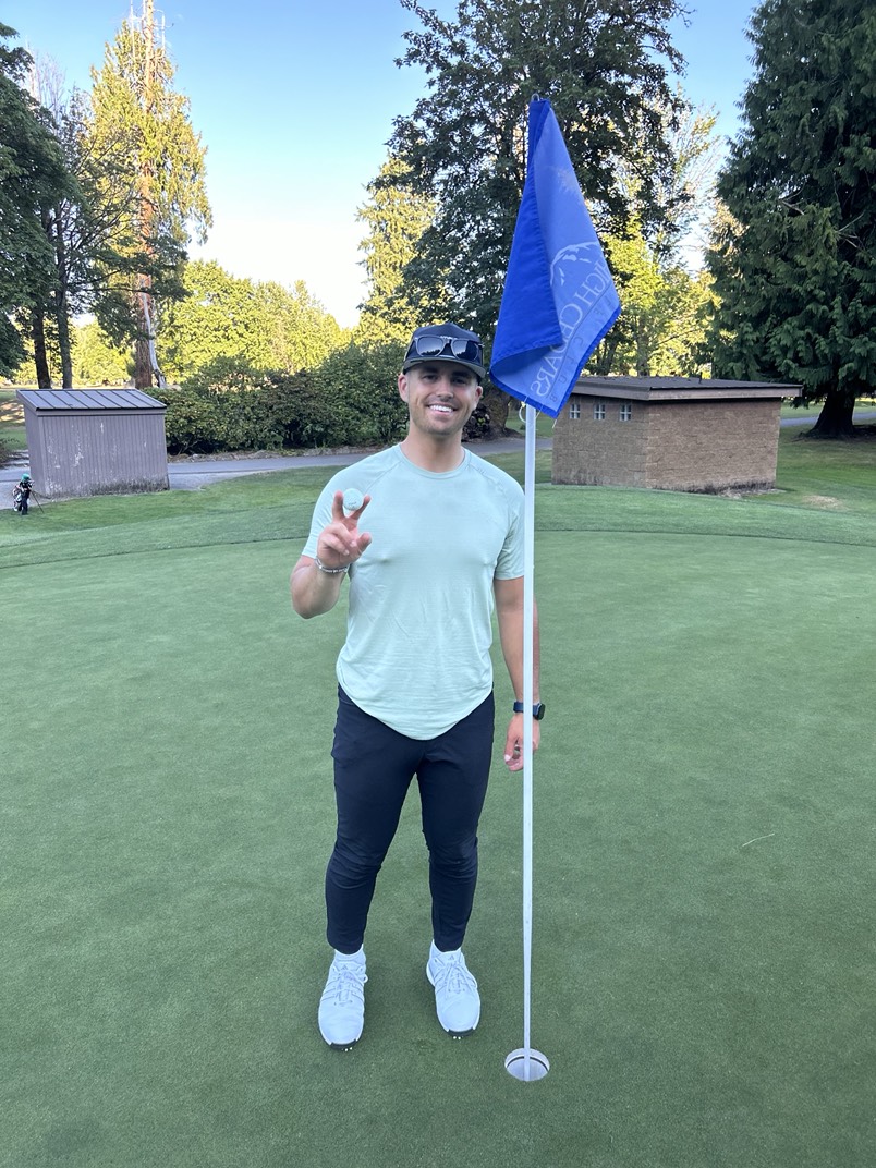 Micah Houston on the green beside the flagstick